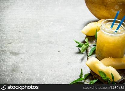 Juice from melons with mint and the pulp. On a stone background.. Juice from melons with mint and the pulp.