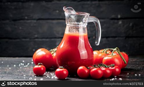 Juice from ripe tomatoes on the table. On a black wooden background. High quality photo. Juice from ripe tomatoes on the table.