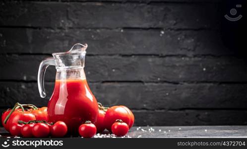 Juice from ripe tomatoes on the table. On a black wooden background. High quality photo. Juice from ripe tomatoes on the table.