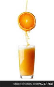 Juice pouring from orange into glass isolated on white background. Juice pouring from orange