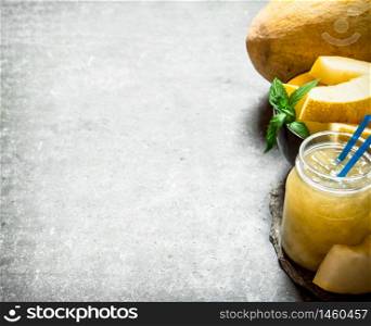 Juice with pulp melon . On a stone background.. Juice with pulp melon .