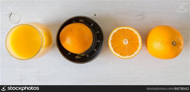 Juicer for orange juice and orange on wooden table.. Juicer for orange juice and orange on wooden table