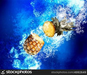 Juicy and healthy. Fresh pineapple in clear blue water splashes