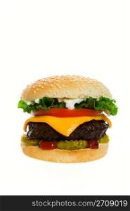 Juicy Angus beef burger topped with cheese, tomatoes & lettuce on a golden sesame seed bun. Shot on white background.