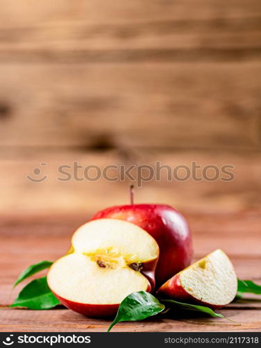 Juicy apples with leaves on the table. On a wooden background. High quality photo. Juicy apples with leaves on the table.