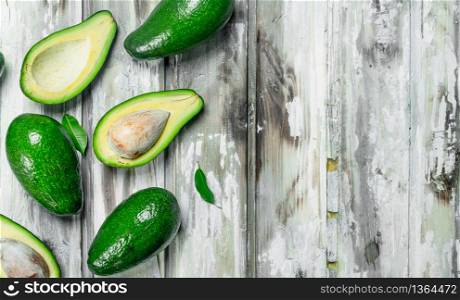 Juicy avocado with leaves. On a white wooden background.. Juicy avocado with leaves.