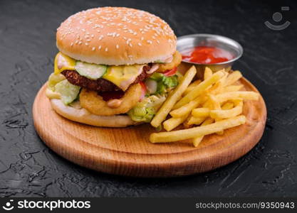 Juicy burger with onion rings and french fries