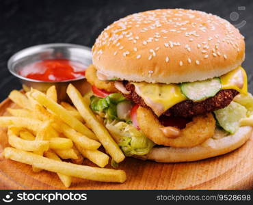 Juicy burger with onion rings and french fries