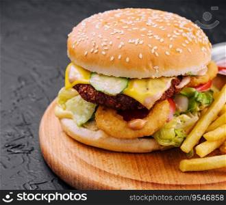 Juicy burger with onion rings and french fries