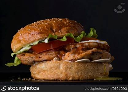 juicy cheeseburger on a black background, close-up. fast food on a black background