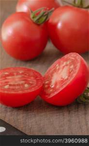 Juicy Cherry tomatoes on wooden background closeup