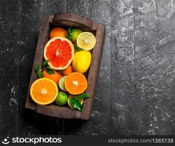 Juicy citrus in a wooden box. On black rustic background. Juicy citrus in a wooden box.