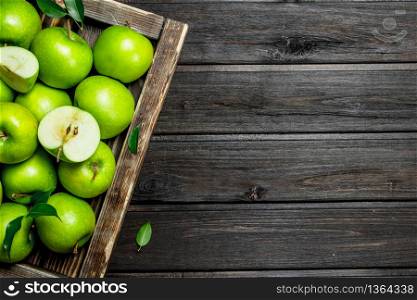 Juicy green apples and Apple slices in a wooden box. On a dark wooden background.. Juicy green apples and Apple slices in a wooden box.