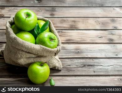 Juicy green apples in an old bag. On grey wooden background.. Juicy green apples in an old bag.
