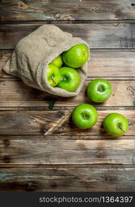 Juicy green apples in an old bag. On grey wooden background.. Juicy green apples in an old bag.