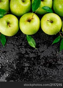Juicy green apples with leaves. On a black background. High quality photo. Juicy green apples with leaves.