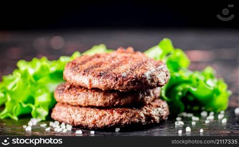 Juicy grilled burger on the table. On a black background. High quality photo. Juicy grilled burger on the table.