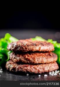 Juicy grilled burger on the table. On a black background. High quality photo. Juicy grilled burger on the table.