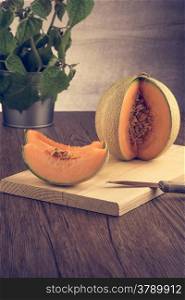 Juicy honeydew melon on a wooden table background.