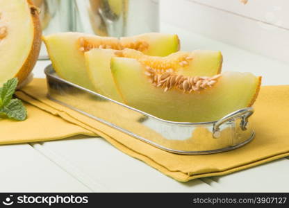 Juicy honeydew melon on a wooden table background.