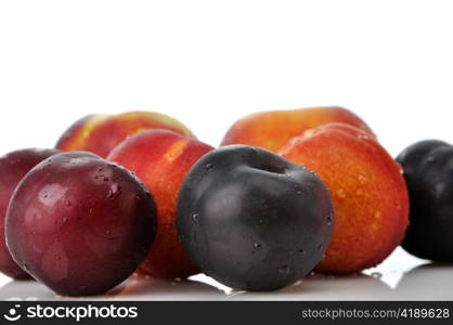 Juicy nectarines, plums and peaches on white background