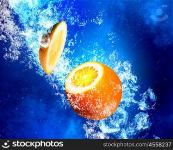 Juicy orange in water . Orange fruit in clear blue water splashes