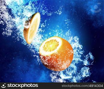 Juicy orange in water. Orange fruit in clear blue water splashes