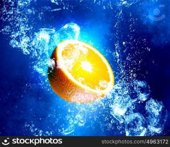 Juicy orange in water. Orange fruit in clear blue water splashes