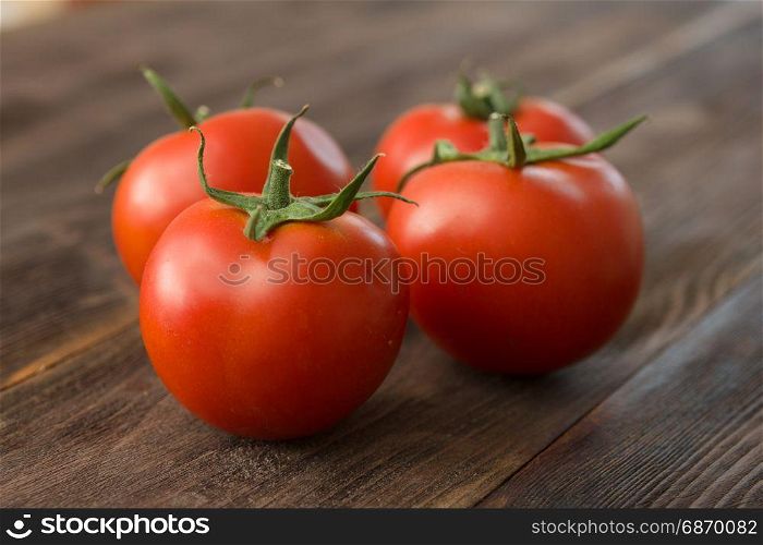 Juicy ripe red tomatoes on a wooden table