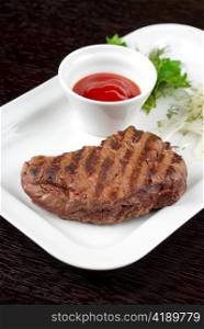 Juicy roasted beef steak with vegetables closeup at plate