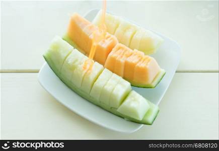 Juicy slice cantaloupe melon on ceramic dish