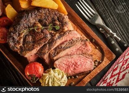 Juicy steak with fragrant butter. Sliced Ribeye Steak with Potatoes, Onions and Baked Cherry Tomatoes.
