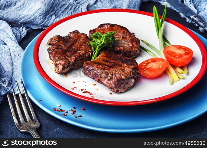 juicy veal steak. Beef with tomato grilled on a plate for dinner