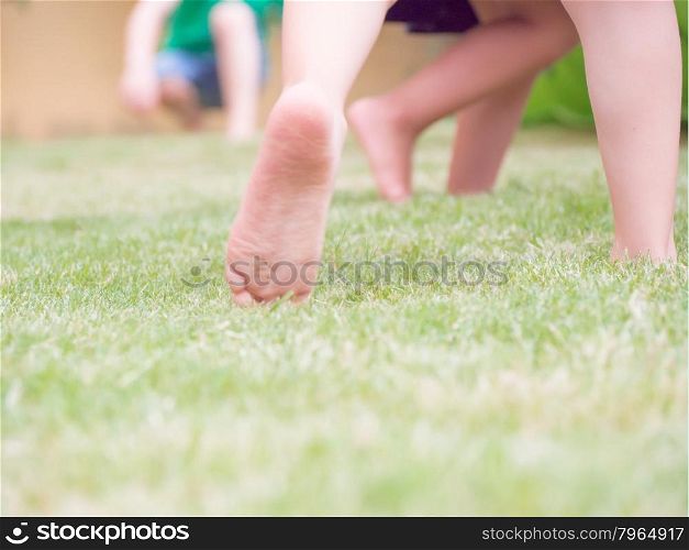 jump on the grass for happiness. Blur image with feet of kid that jump on the grass. Concept of happiness