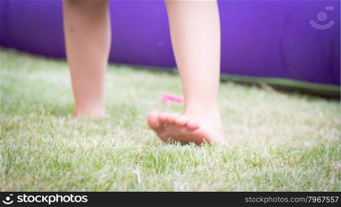 jump on the grass for happiness. Blur image with feet of kid that jump on the grass. Concept of happiness