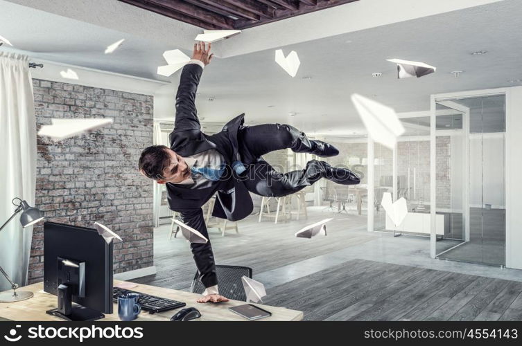 Jumping businessman in office. Funny jumping businessman in modern 3D rendering interior. Mixed media