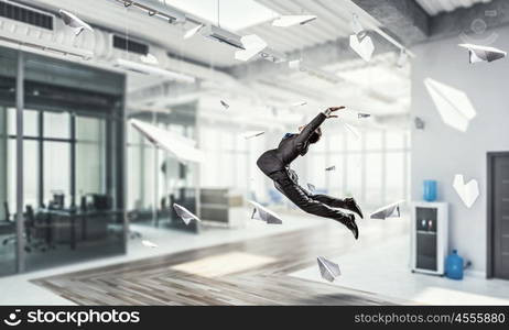 Jumping businessman in office. Funny jumping businessman in modern 3D rendering interior. Mixed media