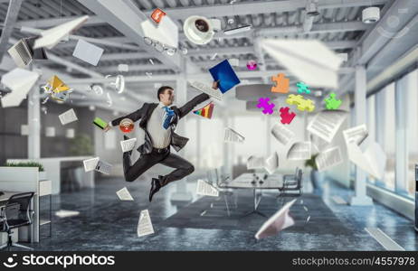 Jumping businessman in office. Funny jumping businessman in modern 3D rendering interior. Mixed media