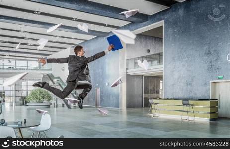 Jumping businessman in office. Funny jumping businessman in modern 3D rendering interior. Mixed media