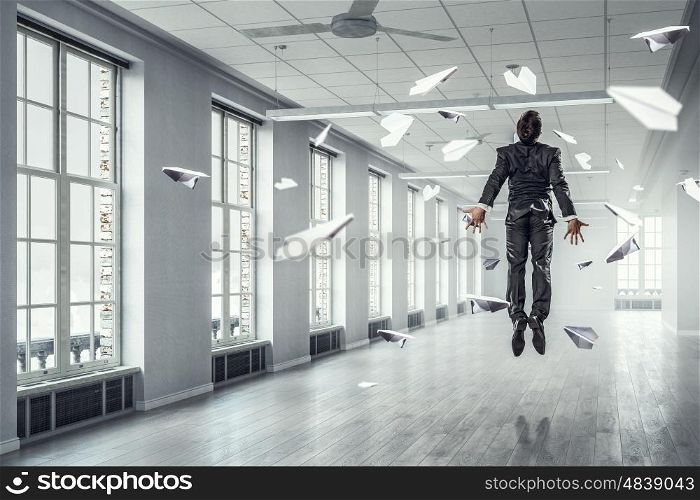 Jumping businessman in office. Funny jumping businessman in modern 3D rendering interior. Mixed media