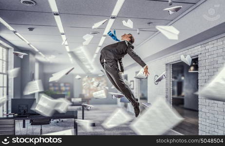 Jumping businessman in office. Funny jumping businessman in modern 3D rendering interior. Mixed media