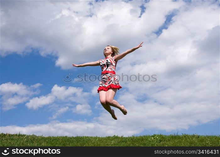 jumping girl on the green meadow