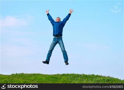 Jumping man on the hill with green grass