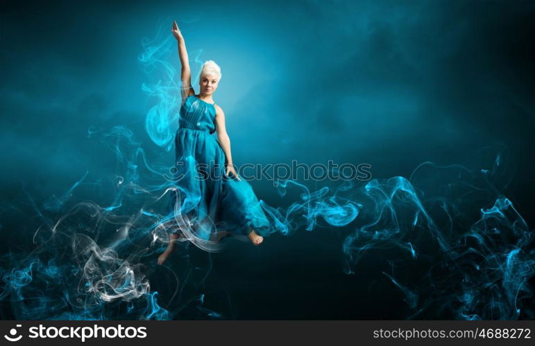 Jumping woman. Young attractive woman in blue dress jumping high