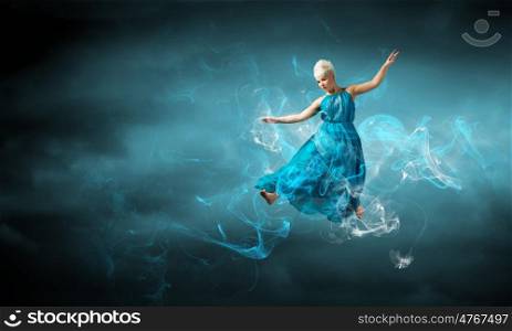 Jumping woman. Young attractive woman in blue dress jumping high