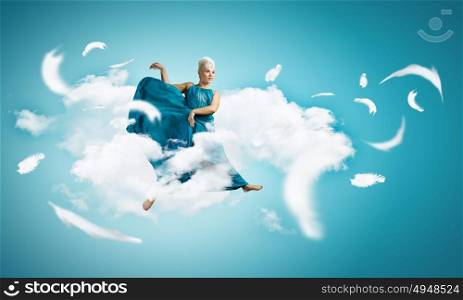 Jumping woman. Young attractive woman in blue dress jumping high