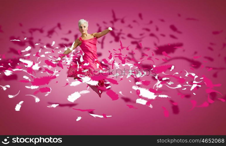 Jumping woman. Young attractive woman in pink dress jumping high