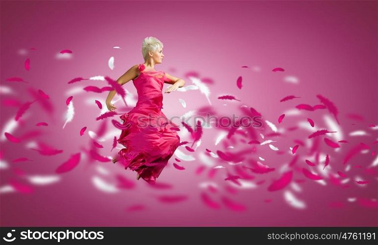 Jumping woman. Young attractive woman in pink dress jumping high