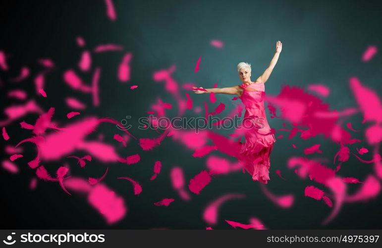 Jumping woman. Young attractive woman in pink dress jumping high