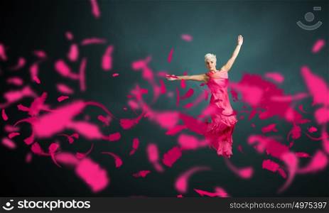 Jumping woman. Young attractive woman in pink dress jumping high